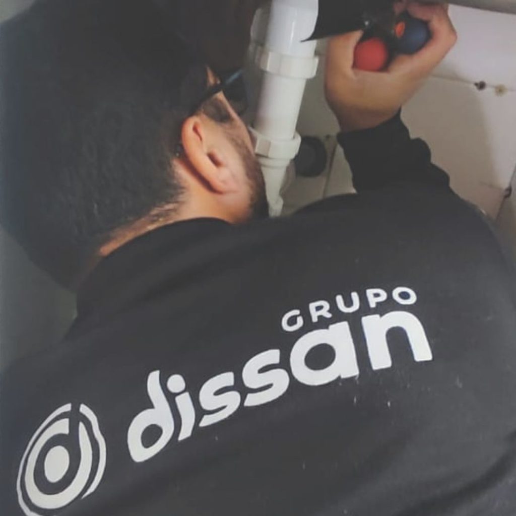 Técnico de Grupo Dissan revisando instalación de fontanería para evitar fugas de agua en local retail.